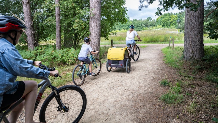 A family setting out on bikes to explore Calke Abbey, Derbyshire
